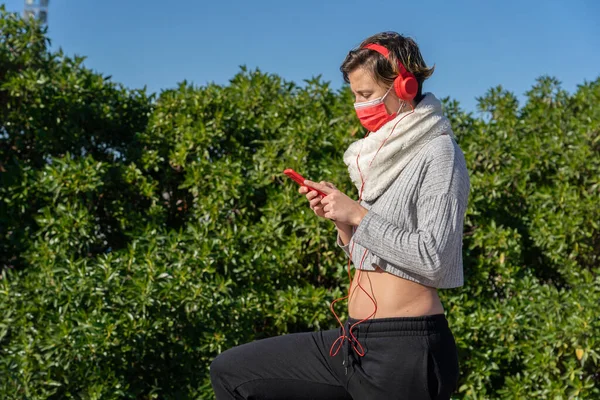 Een Vrouw Met Een Gezichtsmasker Die Naar Muziek Luistert Haar — Stockfoto