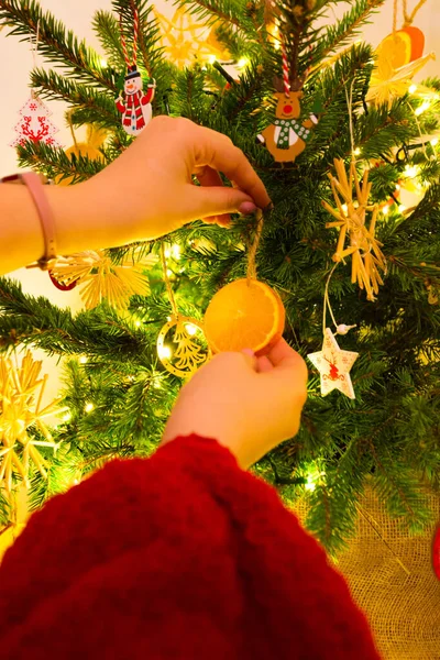 Tiro Vertical Uma Mulher Pendurando Ornamento Fru Uma Árvore Natal — Fotografia de Stock