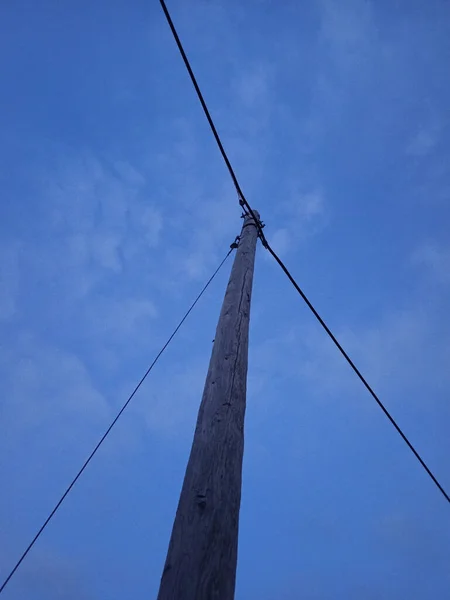 Mavi Gökyüzü Arka Planında Kablo Bulunan Tahta Bir Elektrik Direğinin — Stok fotoğraf
