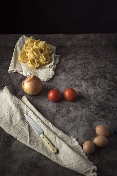 Μια Εναέρια Λήψη Φρέσκων Κρεμμυδιών Αυγών Τοματών Και Ωμών Ζυμαρικών — Φωτογραφία Αρχείου