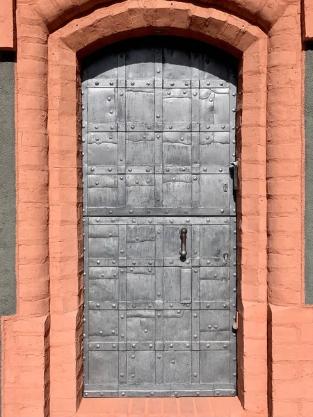 Eine Vertikale Aufnahme Einer Gewölbten Metalltür Eines Orangefarbenen Gebäudes — Stockfoto