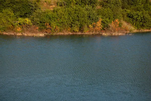 Tiro Ângulo Alto Lago Calmo Lado Uma Colina Cheia Folhagem — Fotografia de Stock