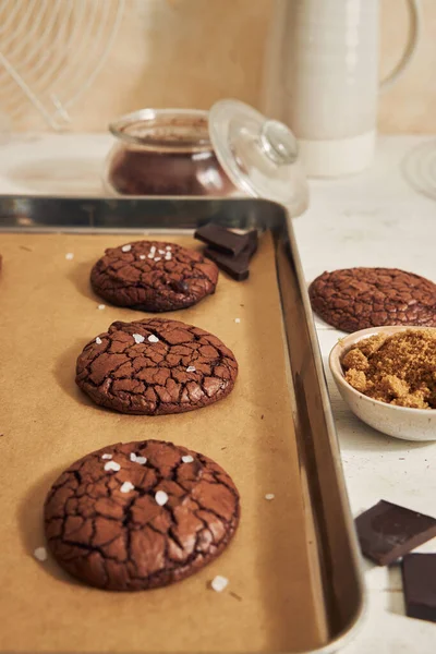 Vertikální Záběr Lahodné Čokoládové Sušenky Ingrediencemi Bílém Stole — Stock fotografie