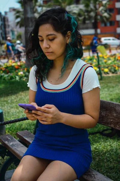Вертикальный Снимок Женщины Голубыми Волосами Болтающей Телефоном Парке — стоковое фото