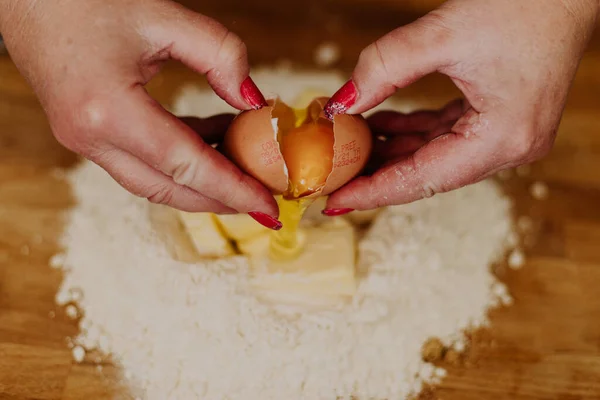 Κοντινό Πλάνο Μιας Γυναίκας Σπάει Ένα Αυγό Στο Αλεύρι Κομμένο — Φωτογραφία Αρχείου