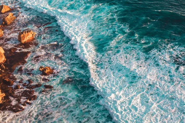 インドンのバリの太陽の下で海に囲まれた岩の高い角度のショット — ストック写真