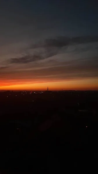 Tiro Vertical Pôr Sol Laranja Sobre Uma Cidade Escura — Fotografia de Stock