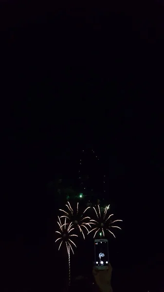 아름다운 불꽃놀이로 빛나는 밤하늘을 포착하는 전화기의 — 스톡 사진