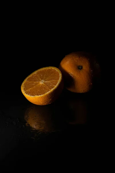 黒の背景に隔離されたスライスされたオレンジの垂直閉鎖 — ストック写真
