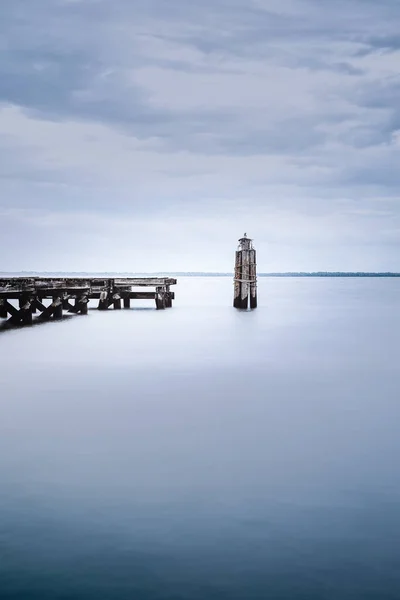 在阴郁的一天背景下 一个木制码头附近平静的大海 — 图库照片