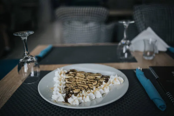 ホワイトプレートにホイップクリームとチョコレートトッピングとクレープの選択的フォーカスショット — ストック写真