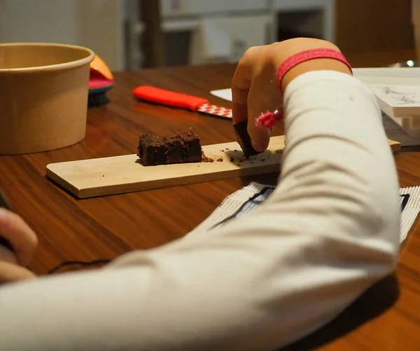 Selective Focus Shot Female Hand Pieces Fresh Brownie Wooden Board — Stock Photo, Image