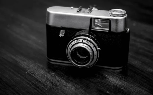 Graustufenaufnahme Einer Vintage Kamera Auf Einem Holztisch Mit Verschwommenem Hintergrund — Stockfoto
