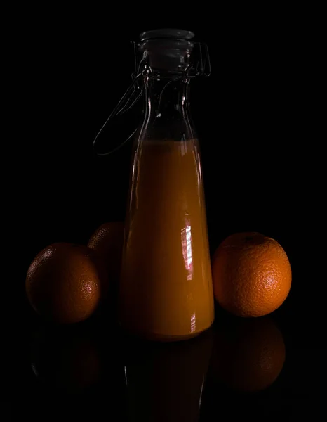 Függőleges Narancslé Egy Palack Fekete Háttérrel Árnyékok Alatt — Stock Fotó