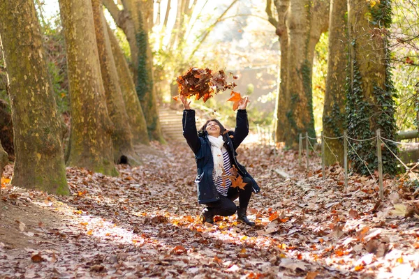 Uma Mulher Hispânica Alegre Joelhos Jogando Folhas Outono Parque Collserola — Fotografia de Stock