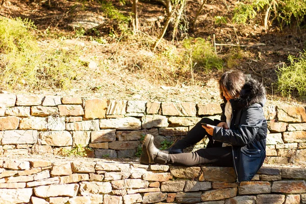 Eine Junge Hispanische Frau Mantel Sitzt Auf Einer Steinmauer Während — Stockfoto