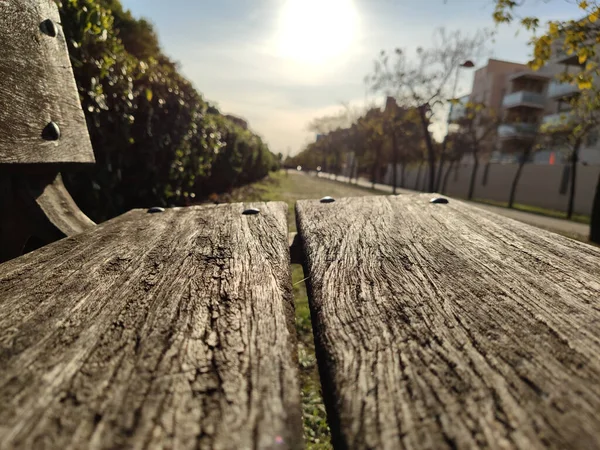 在阳光明媚的天气背景下 一张木制长椅和住宅的选择性焦点照片 — 图库照片