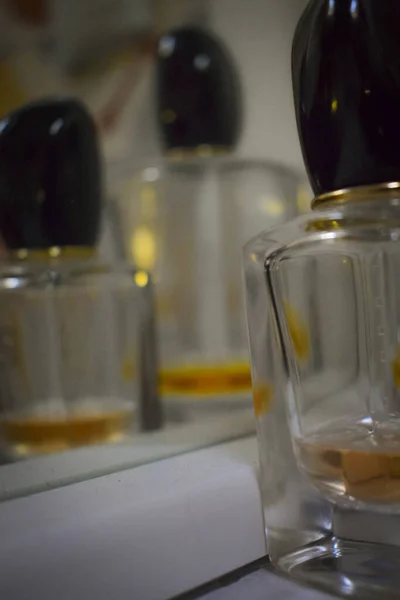 Een Verticaal Shot Van Een Fles Parfum Tegen Een Spiegel — Stockfoto