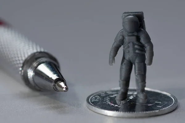 Eine Nahaufnahme Einer Münze Einer Gedruckten Astronautenfigur Und Eines Kugelschreibers — Stockfoto