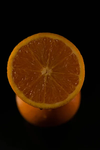 Вертикальный Снимок Срезанного Мокрого Апельсина Ломтика Черном Фоне — стоковое фото