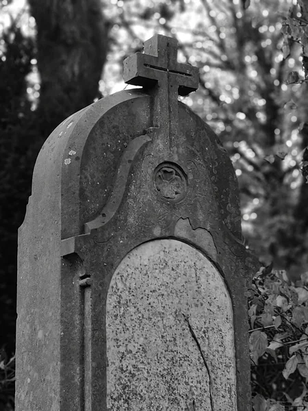 Eine Vertikale Graustufenaufnahme Eines Alten Grabsteins Mit Einem Cros — Stockfoto