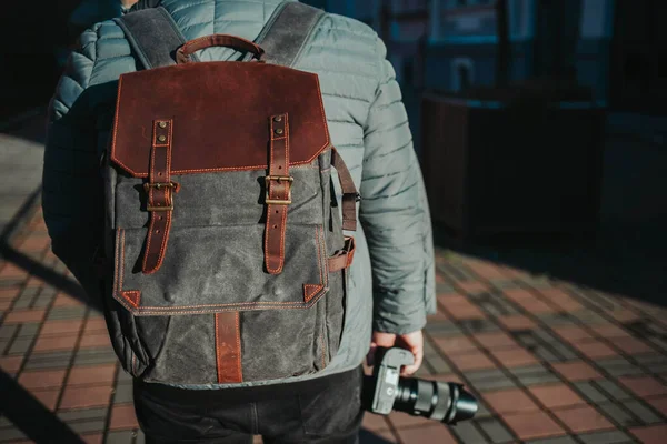 在街上散步时 男人背着背包 拿着相机的有选择的焦点镜头 — 图库照片
