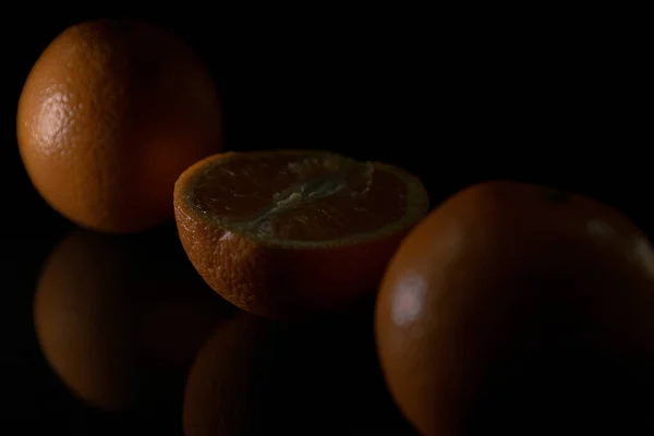 Een Close Van Gesneden Sinaasappels Geïsoleerd Een Zwarte Achtergrond Onder — Stockfoto