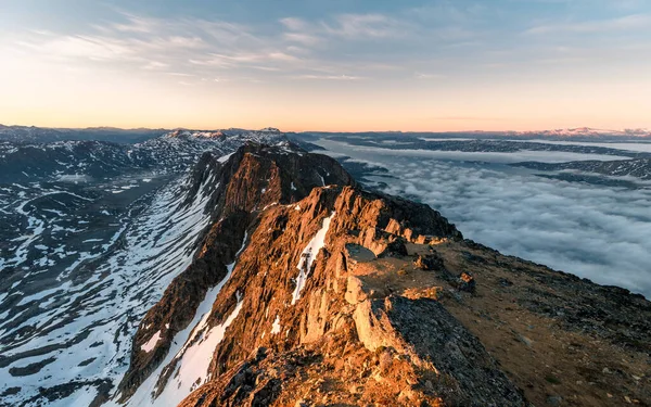 日出时 空中拍摄的雪山在云彩之上的最高峰 — 图库照片