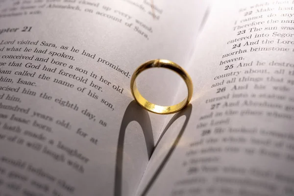 Closeup Golden Engagement Ring Forming Shadow Heart Open Holy Bible — Stock Photo, Image