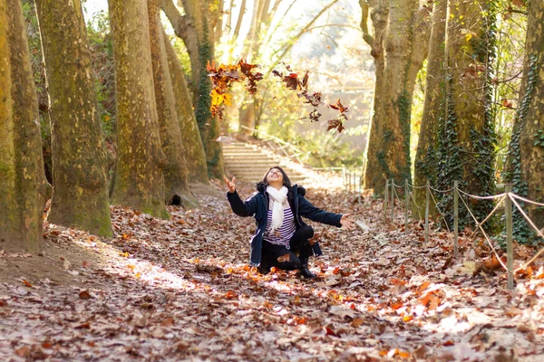 Uma Mulher Hispânica Alegre Joelhos Jogando Folhas Outono Parque Collserola — Fotografia de Stock