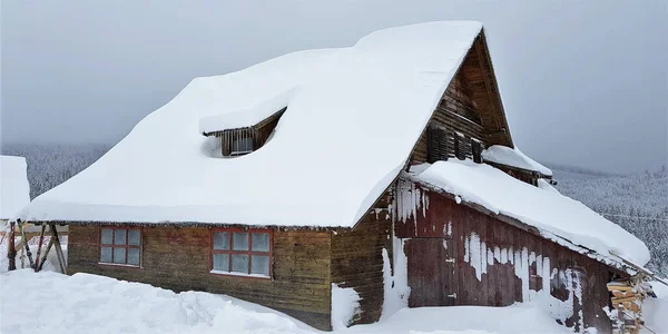 森の中の寒い冬の日に雪に覆われたログハウスの美しいショット — ストック写真