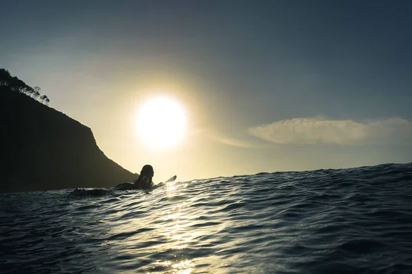 夕阳西下 一个年轻的冲浪女孩带着冲浪板在海里拍了一张漂亮的照片 — 图库照片