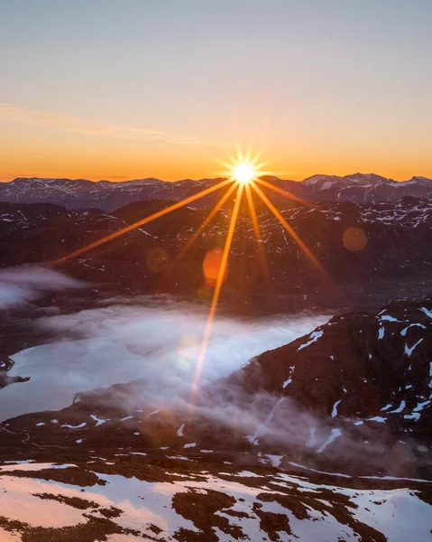 日出时 白雪覆盖的高山在云彩之上的一个垂直的镜头 — 图库照片