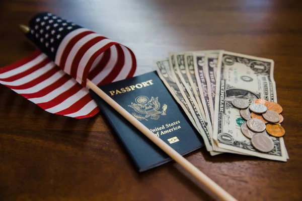 护照和钱旁边的一面小美国国旗 — 图库照片