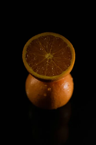 カットされたオレンジ色の垂直ショットと黒の背景に隔離されたスライス — ストック写真