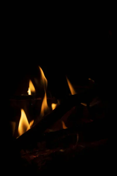 黒を背景に夜のオレンジの火の美しい垂直ショット — ストック写真