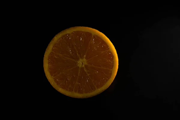 클로저 촬영젖은 오렌지 조각과 그것의 반사검은 배경에 — 스톡 사진