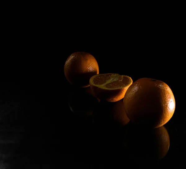 影の下の黒い背景に隔離されたスライスされたオレンジの塊 — ストック写真