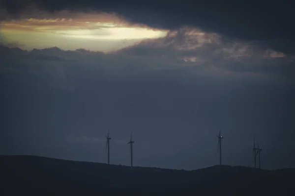 Uma Vista Panorâmica Dos Moinhos Vento Topo Uma Colina Durante — Fotografia de Stock