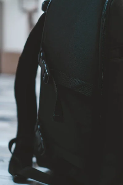 在模糊的背景前 一个黑色背包的垂直特写 — 图库照片