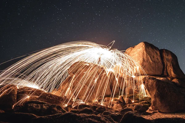 A beautiful steel wool shot of the motion of hot embers flying through the air