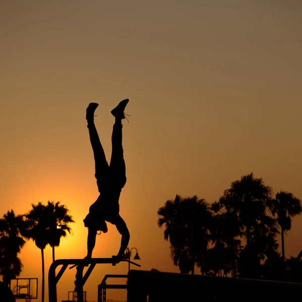 Eine Vertikale Aufnahme Eines Mannes Silhouette Balanciert Seinen Körper Auf — Stockfoto