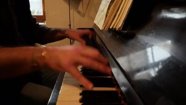 Homem Tocando Piano Usando Duas Pulseiras Douradas Papéis Manuscritos Rack — Vídeo de Stock