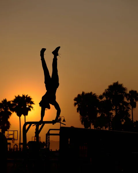 Disparo Vertical Una Silueta Hombre Balanceando Cuerpo Las Manos Puesta — Foto de Stock