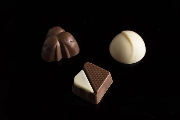 Pequenos Pedaços Chocolate Escuro Branco Colocados Sobre Fundo Preto — Fotografia de Stock