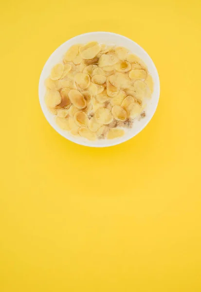 Colpo Verticale Cornflakes Con Latte Una Ciotola Isolata Fondo Giallo — Foto Stock
