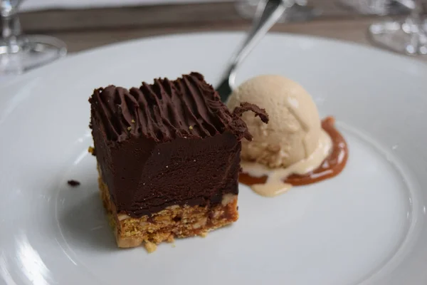 ホワイトプレートにアイスクリームとチョコレートのおいしいケーキのクローズアップショット — ストック写真