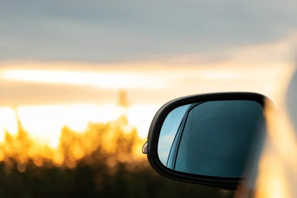 背景に美しい日の出を持つ車のサイドミラーの選択的なフォーカスショット — ストック写真