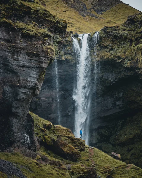 山の中の滝の美しい景色を楽しむ岩の上に立つ人 — ストック写真