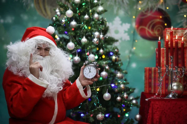 Santa Claus Sitting Festive New Year Tree Holding Silver Clock — Stock Photo, Image